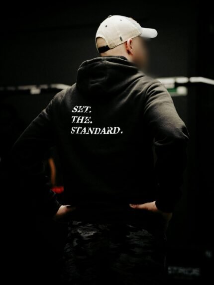 Black hoodie from The Trace featuring Set the Standard design symbolizing the pursuit of the highest performance