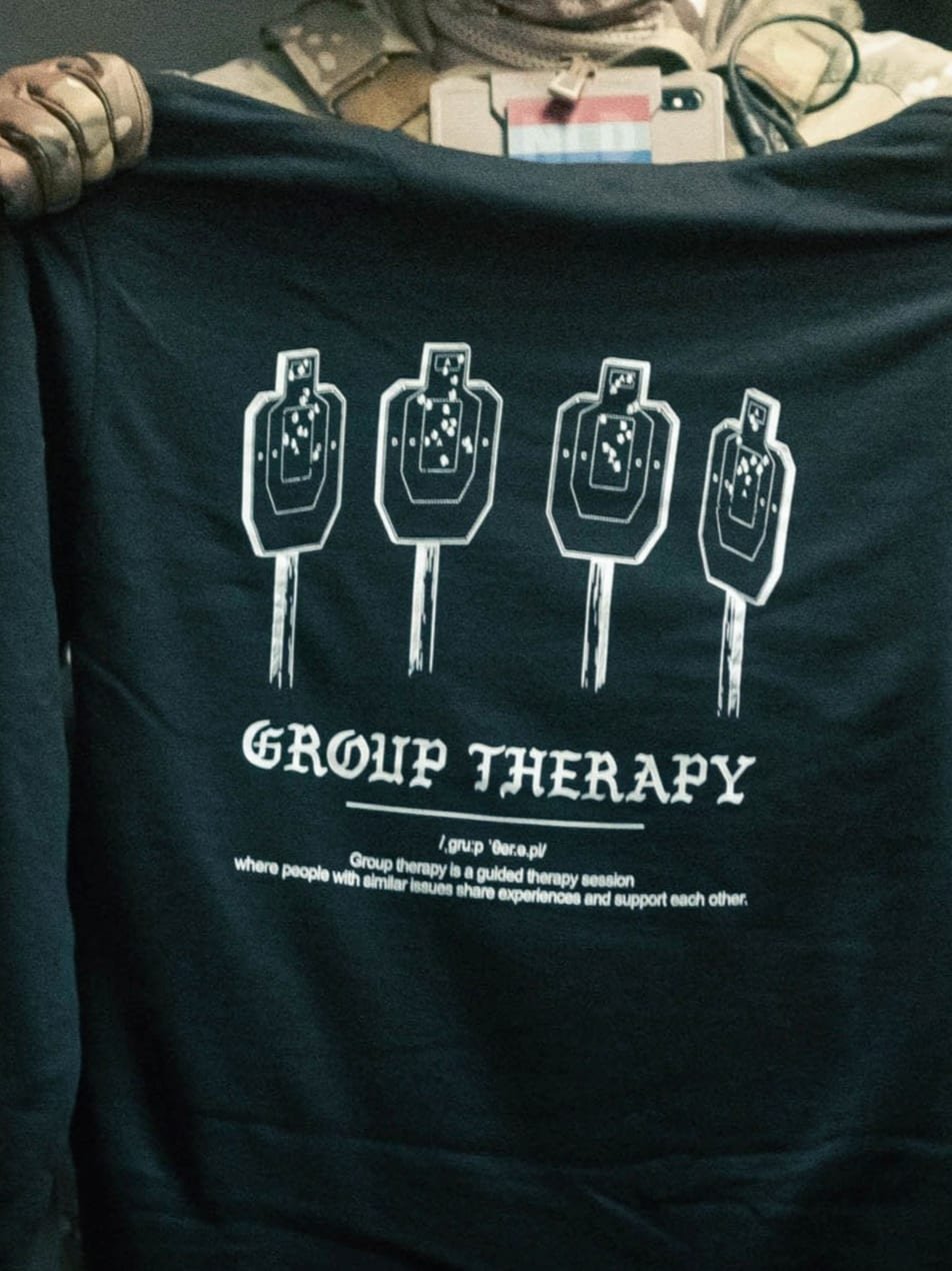 Black hoodie from The Trace featuring Group Therapy design with four targets marked by tight bullet hole groupings