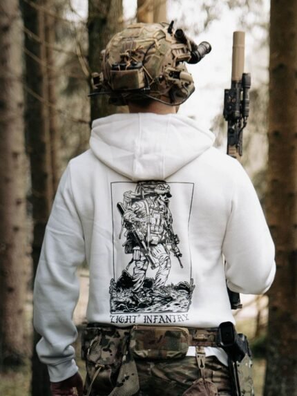 white hoodie from The Trace depicting Light Infantry design with a soldier standing with a heavy backpack