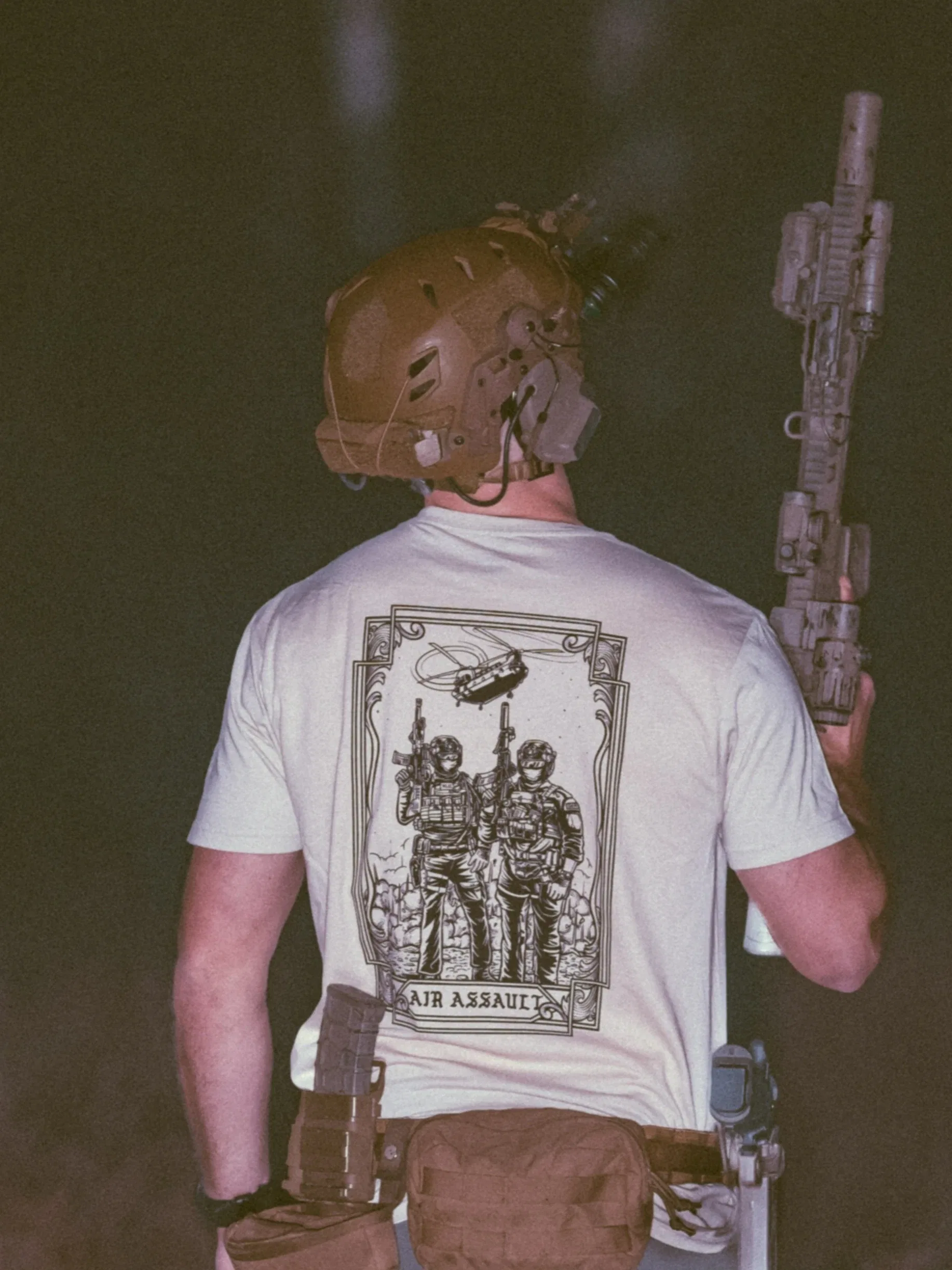 the trace apparel collection featuring 2 air assault operators standing in front of a chinook