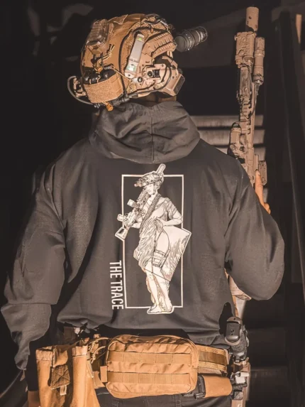 black hoodie from The Trace featuring a girl carrying a machinegun