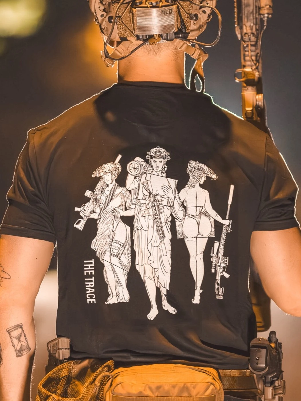 black shirt from The Trace featuring 3 girls carrying a machinegun sniperrifle and anti tank weapon