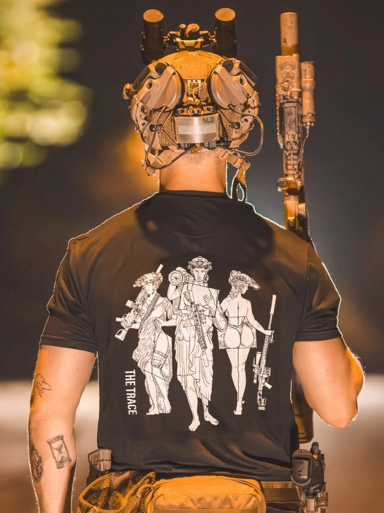 black shirt from The Trace featuring 3 girls carrying a machinegun sniperrifle and anti tank weapon