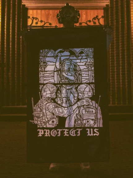 the trace apparel collection featuring a military and a police guy standing in front of a tinted window that displays saint michael the protector