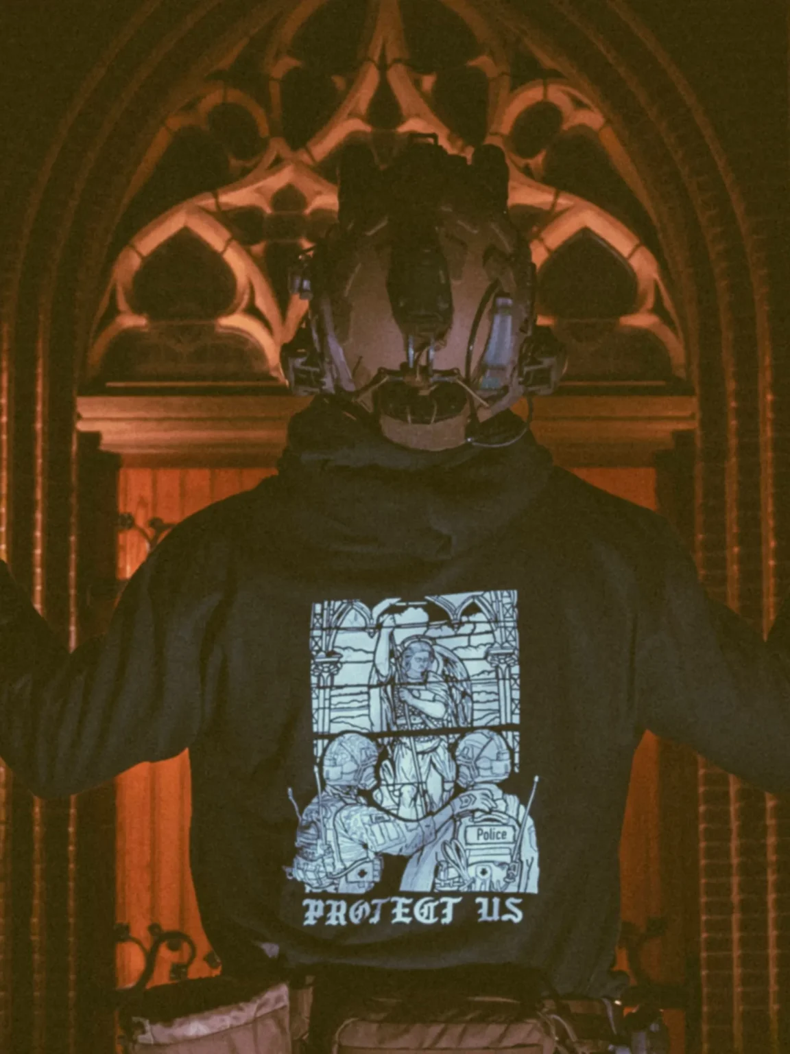 the trace apparel collection featuring a military and a police guy standing in front of a tinted window that displays saint michael the protector