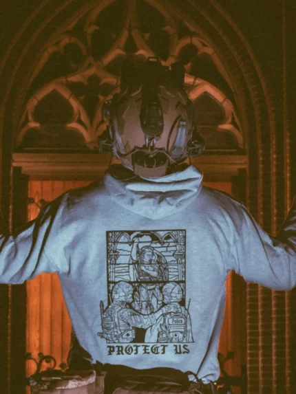the trace apparel collection featuring a military and a police guy standing in front of a tinted window that displays saint michael the protector