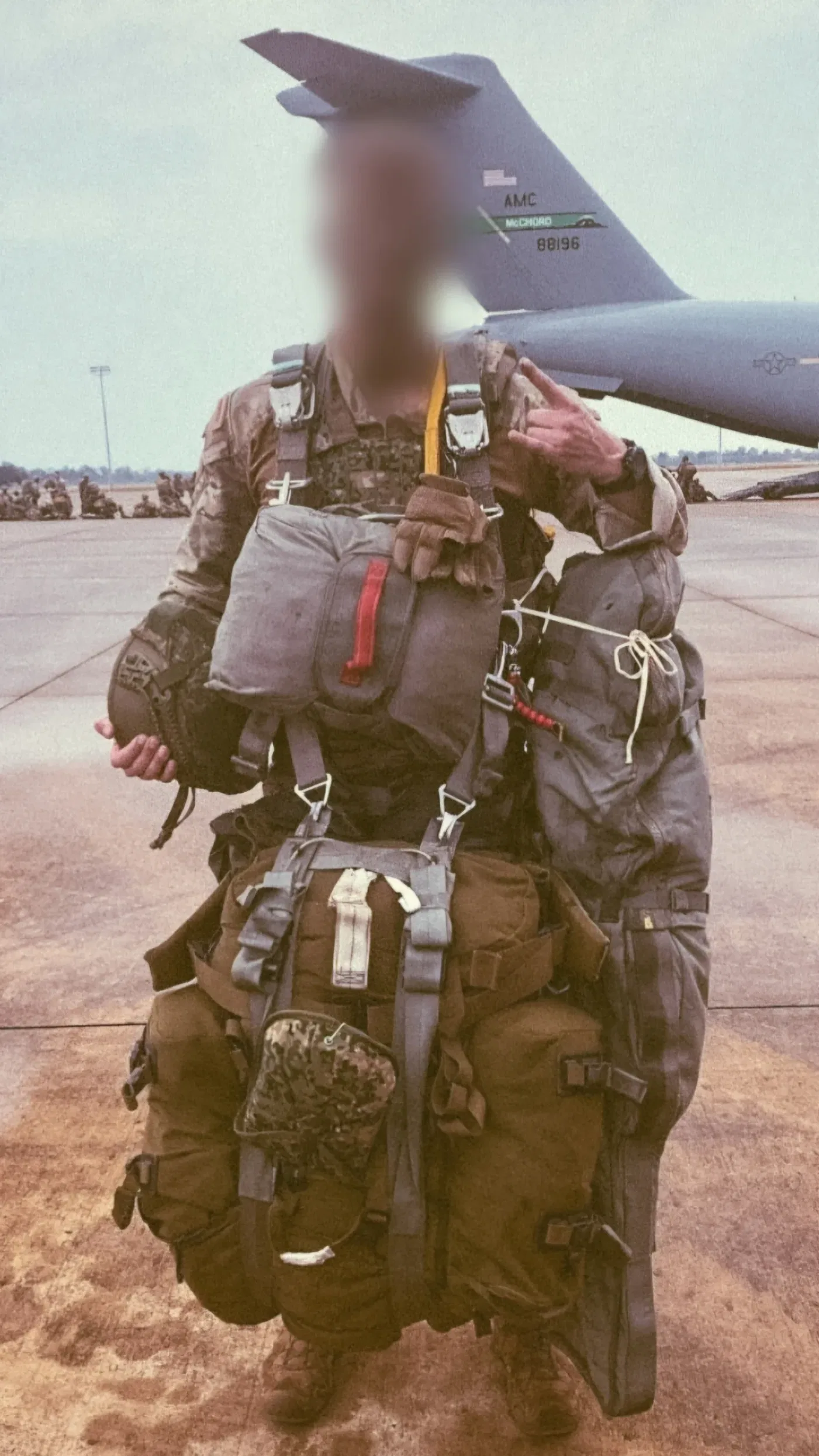 Dutch sniper carrying around 80 kilos of equipment before a static line jump, C-17 transport aircraft behind him