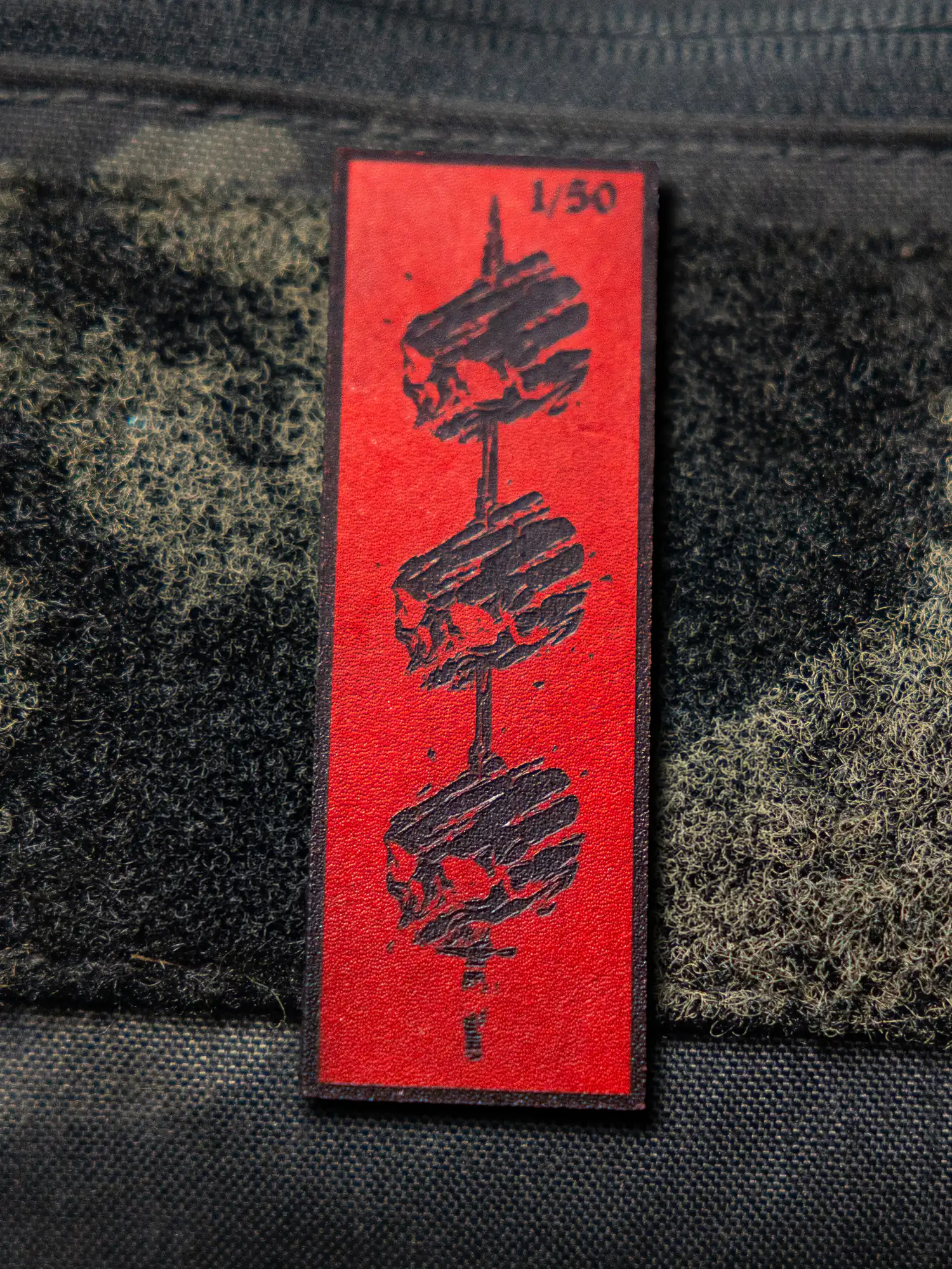 Tier 1 Controlled Chaos Patch in numbered black on red, leather patch close-up by The Trace